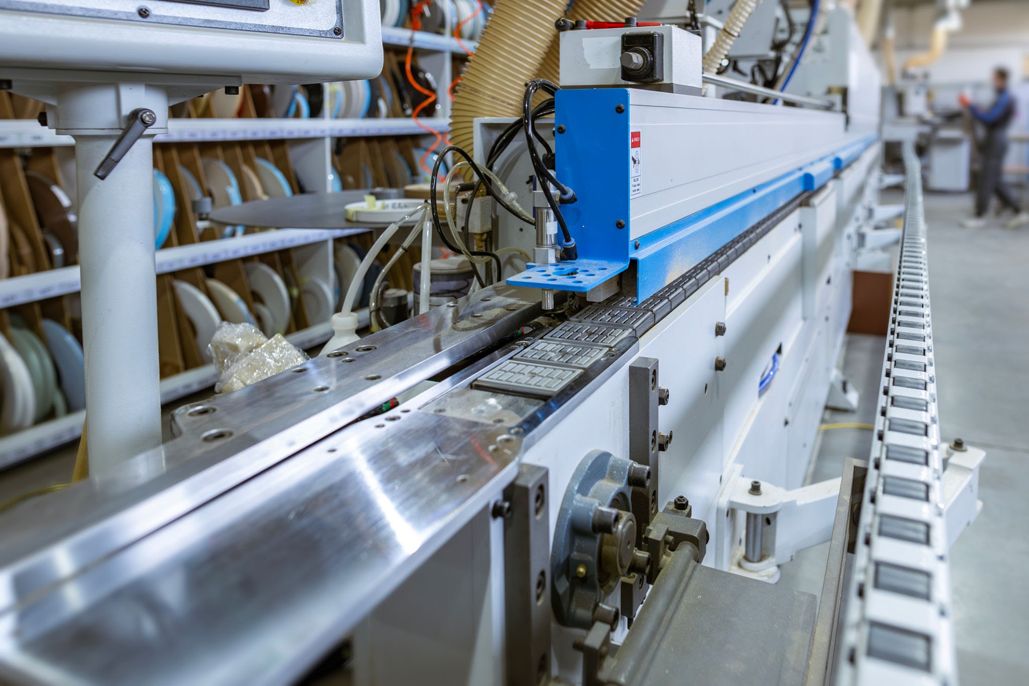 Automatic edge banding machine processing panels on a furniture production line